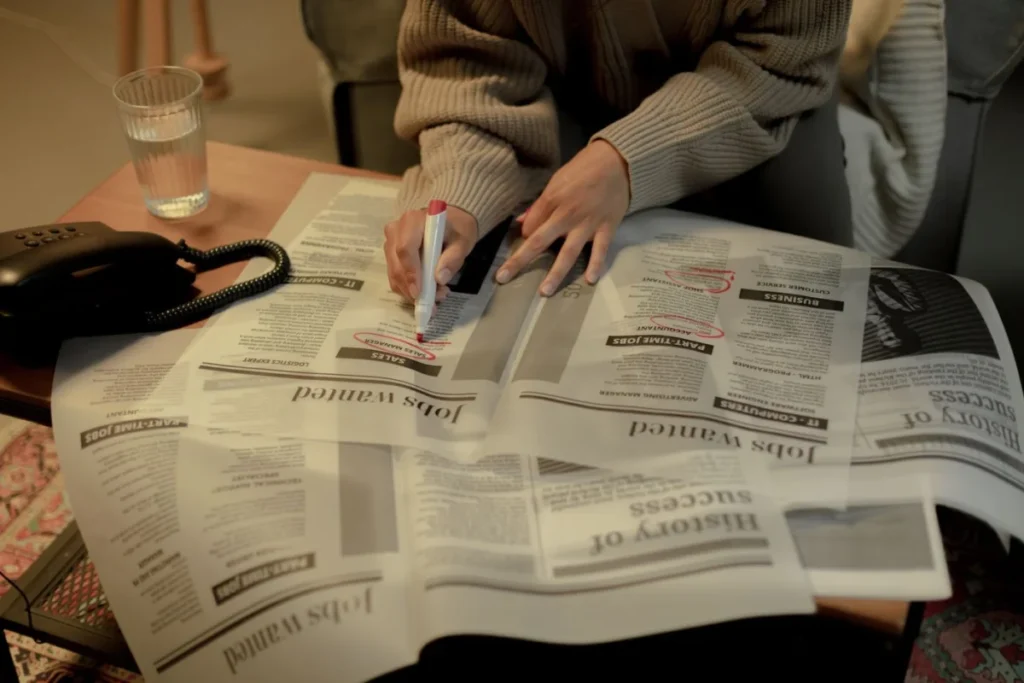 Woman marking job listings in a newspaper