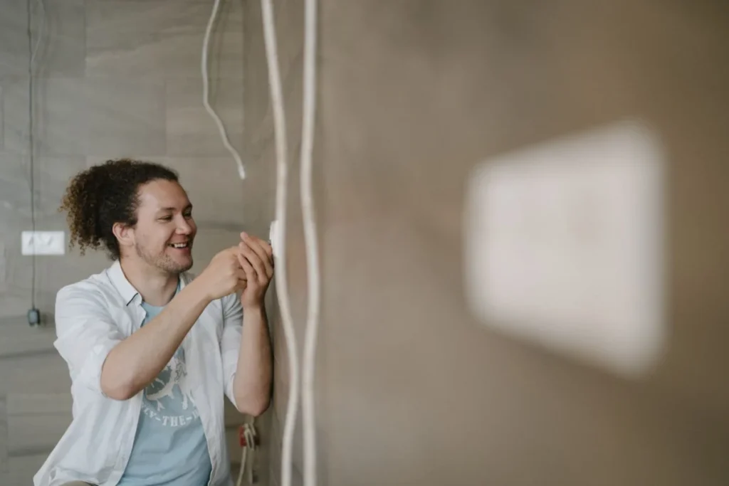 Electrician adjusting an outlet indoors