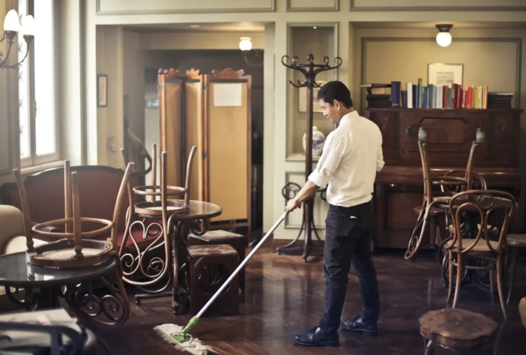Man mopping the floor in a cafe