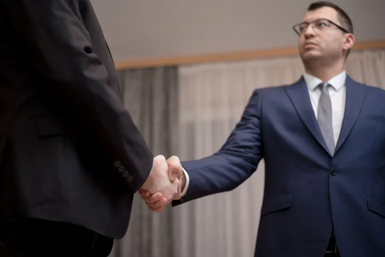 Business partners shaking hands, showing the benefits of using a staffing agency