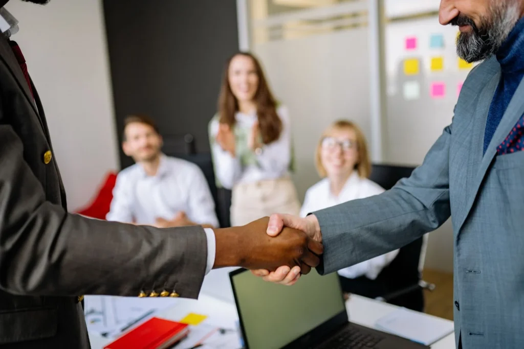 Close-up of a handshake between colleagues in a professional office setting