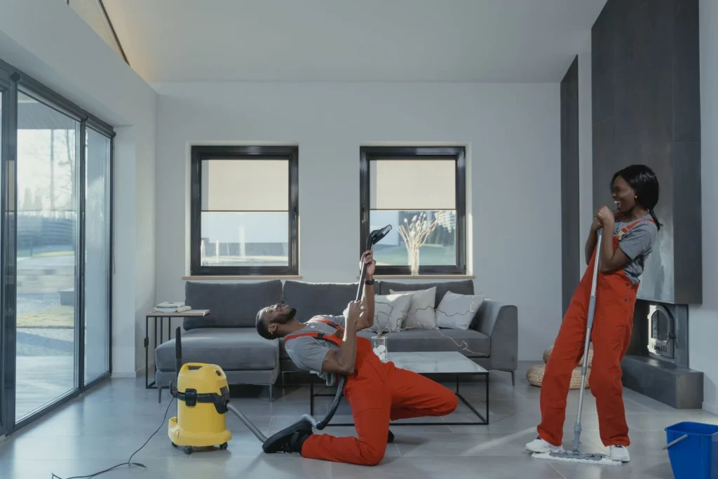 Two cleaners in overalls using cleaning tools, a common task in custodian jobs