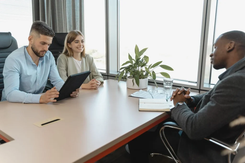 A business interview with three people in a modern office room, highlighting collaboration