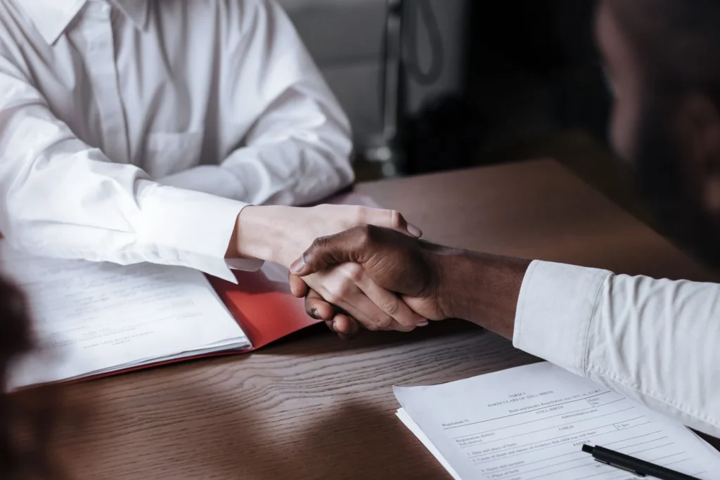Close-up of a diverse business handshake over documents, symbolizing agreement and collaboration