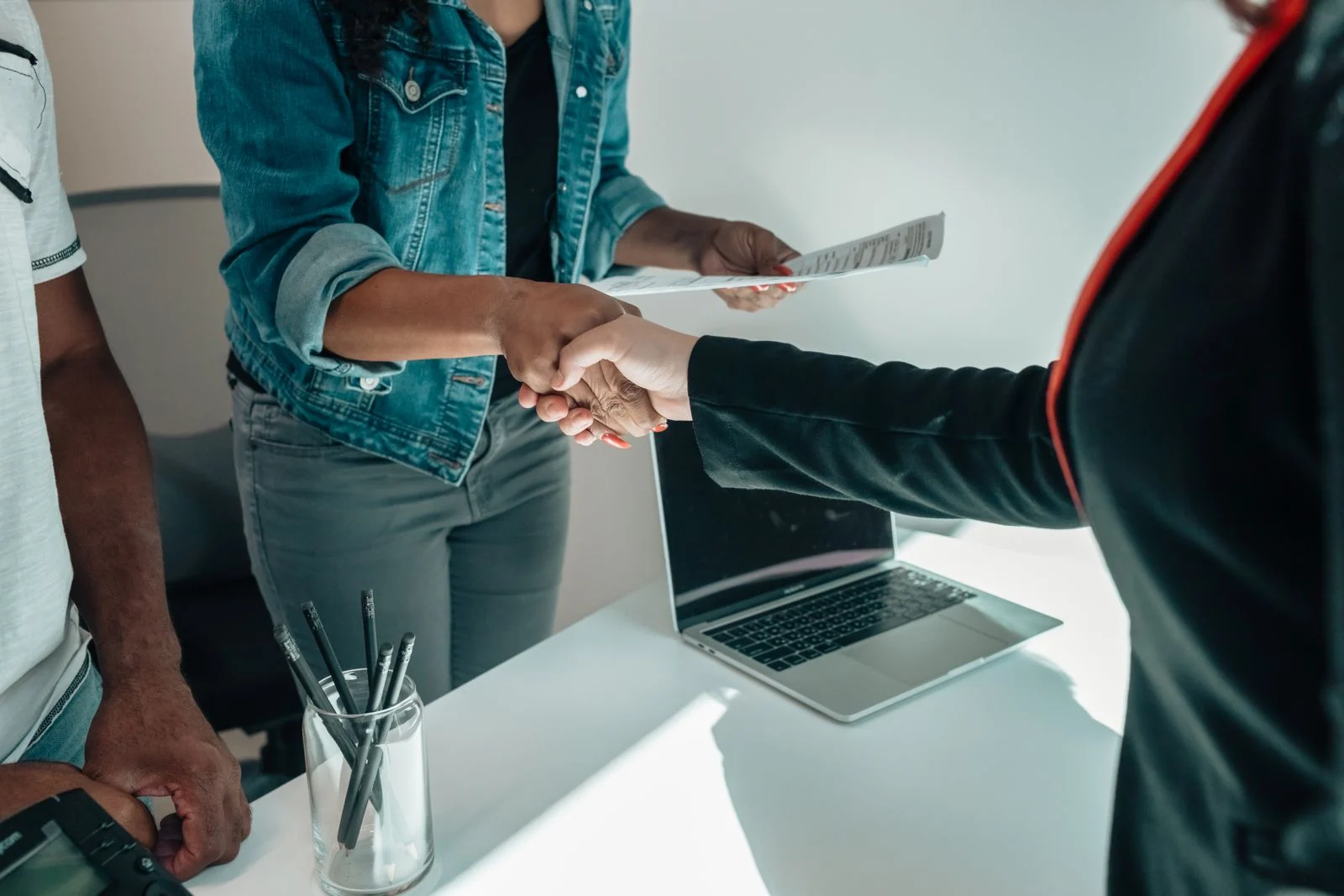 Employer and new hire shaking hands after choosing between temp agency vs direct hire