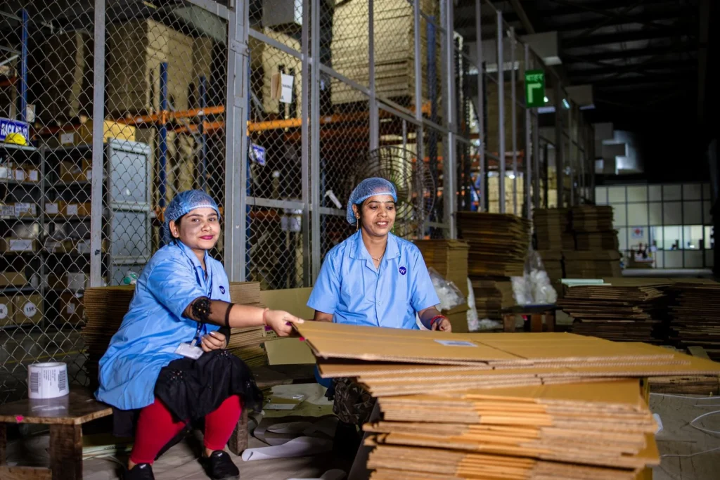 Temporary staffing workers handling cardboard boxes in a warehouse