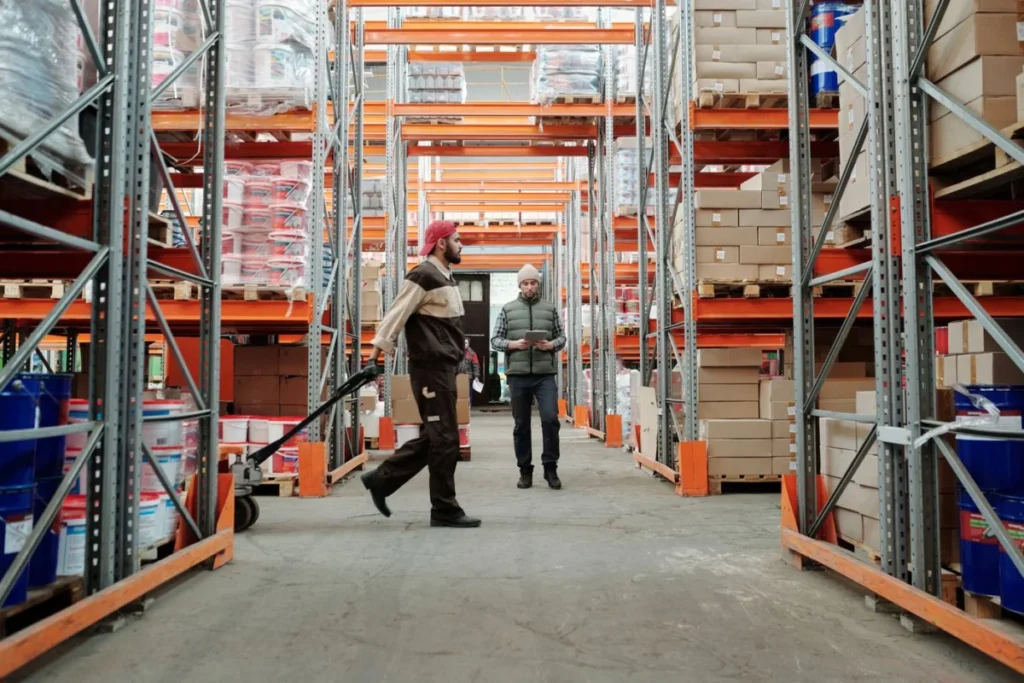Two workers managing inventory in a warehouse aisle